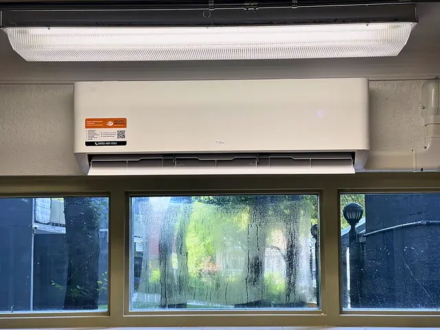 Ductless indoor unit mounted above office windows