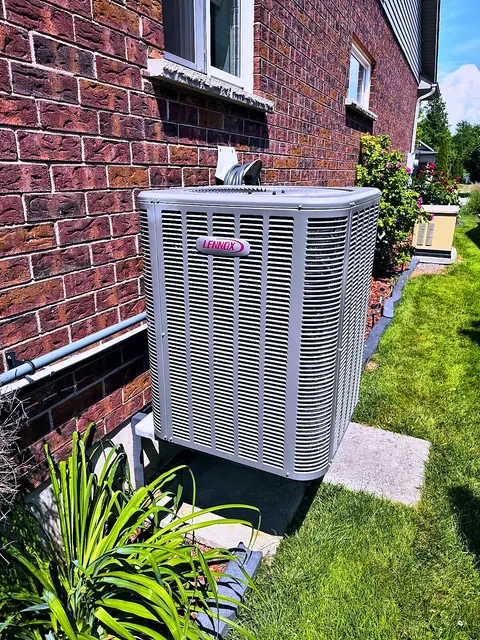 Outdoor unit on a concrete pad beside a brick home